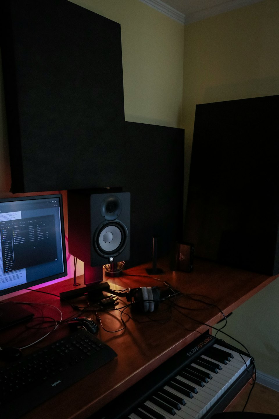 Domowe studio muzyczne z klawiaturą i monitorem.
