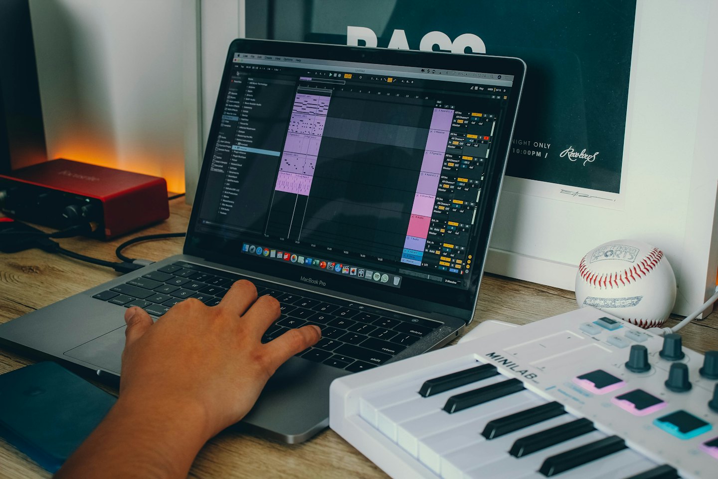 Ręczna edycja muzyki na laptopie przy drewnianym biurku.