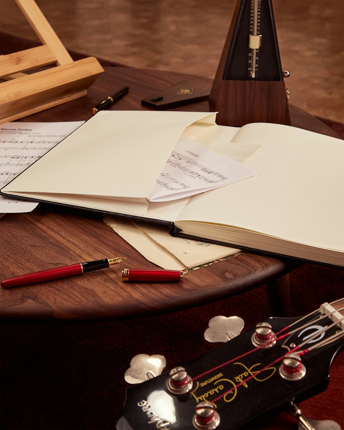 Instrumenty muzyczne i nuty ułożone na drewnianym biurku.